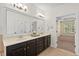 A bathroom boasts a double vanity with a large mirror and access to the bedroom at 108 Teagan Ct, Chapel Hill, NC 27516