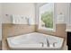 A bathtub is situated under a window for natural light at 108 Teagan Ct, Chapel Hill, NC 27516