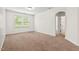 Bedroom with neutral carpeting, natural light, and an adjoining bathroom or closet through arched doorway at 108 Teagan Ct, Chapel Hill, NC 27516