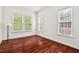 Bedroom with hardwood floors, three windows with blinds, and neutral paint at 108 Teagan Ct, Chapel Hill, NC 27516