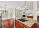 Kitchen island featuring cooktop with view to living area with fireplace and outdoor access at 108 Teagan Ct, Chapel Hill, NC 27516