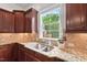 Kitchen sink area showcasing granite countertops, tile backsplash, and natural light through a large window at 108 Teagan Ct, Chapel Hill, NC 27516