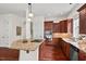 Bright kitchen featuring a granite island with cooktop, wooden cabinetry, and stainless steel appliances at 108 Teagan Ct, Chapel Hill, NC 27516
