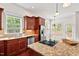Kitchen area with island cooktop, stainless steel appliances, and natural light through windows at 108 Teagan Ct, Chapel Hill, NC 27516