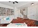 Cozy living room with hardwood floors, custom bookshelves, and a staircase at 108 Teagan Ct, Chapel Hill, NC 27516