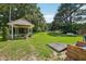 Expansive backyard includes a charming gazebo, mature trees and a lush green lawn at 10900 Poole Rd, Wendell, NC 27591