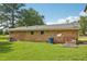 Rear view of brick home shows the backyard with mature trees and the roof with satellites at 10900 Poole Rd, Wendell, NC 27591
