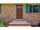 Inviting brick home featuring a solid wood front door and decorative green shutters at 10900 Poole Rd, Wendell, NC 27591