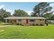 Charming brick home with green shutters and a spacious front yard under a blue sky at 10900 Poole Rd, Wendell, NC 27591