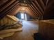 View of a large unfinished attic space with exposed rafters, some insulation and lighting at 12037 Deer Run, Raleigh, NC 27614