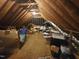 View of a large unfinished attic space with exposed rafters, lighting, and storage boxes at 12037 Deer Run, Raleigh, NC 27614