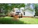 Backyard view featuring a deck, patio furniture, lush green lawn, and deer grazing on the grass at 12037 Deer Run, Raleigh, NC 27614