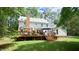 Spacious backyard with a deck, green lawn, and mature trees creating a private and serene outdoor space at 12037 Deer Run, Raleigh, NC 27614