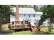 A wooden deck is set in a beautiful backyard with a grill, lounge furniture, and lush greenery at 12037 Deer Run, Raleigh, NC 27614