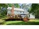 Large backyard showcasing a deck, staircase, lush lawn, chimney, and tasteful landscaping for outdoor living at 12037 Deer Run, Raleigh, NC 27614
