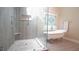 Bright bathroom featuring a glass enclosed shower and separate soaking tub with decorative window at 12037 Deer Run, Raleigh, NC 27614