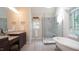 This updated bathroom boasts a stylish glass enclosed shower with a standalone tub at 12037 Deer Run, Raleigh, NC 27614