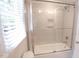 Modern bathroom featuring a sliding glass shower door, gray tiled walls, and a built-in niche at 12037 Deer Run, Raleigh, NC 27614