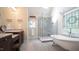 Bright bathroom featuring a modern shower, freestanding tub, and beautiful stained glass window at 12037 Deer Run, Raleigh, NC 27614