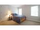 Bedroom with neutral walls, a cozy bed, and two windows letting in natural light at 12037 Deer Run, Raleigh, NC 27614
