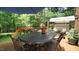 Serene backyard deck with dining table, outdoor umbrella, and an idyllic view of lush green trees at 12037 Deer Run, Raleigh, NC 27614