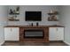Modern entertainment center with a fireplace, TV, floating shelves, and white cabinets against a neutral wall at 121 Longleaf Pine St, Clayton, NC 27527