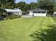 Spacious backyard with lush green grass and a convenient carport at 129 S Bullock St, Henderson, NC 27536