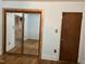 Bedroom with light blue walls, hardwood floors, and a mirrored closet with natural wood trim at 129 S Bullock St, Henderson, NC 27536
