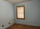 Bedroom featuring laminate flooring and a window with natural wood trim at 129 S Bullock St, Henderson, NC 27536