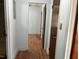 Hallway with laminate flooring, white walls, and several dark wood paneled doors at 129 S Bullock St, Henderson, NC 27536