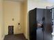 Image of a kitchen area with dated features, including a black refrigerator and an unfinished section of wall at 129 S Bullock St, Henderson, NC 27536