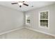 Neutral bedroom featuring carpeted floors, ceiling fan, and double windows for natural light at 1304 Trailing Rose Ct, Wake Forest, NC 27587