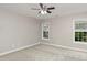 Neutral bedroom featuring carpeted floors, ceiling fan, and double windows for natural light at 1304 Trailing Rose Ct, Wake Forest, NC 27587