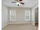 Neutral bedroom featuring carpeted floors, ceiling fan, and double windows for natural light at 1304 Trailing Rose Ct, Wake Forest, NC 27587