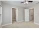 Neutral bedroom featuring carpeted floors, ceiling fan, and doors to closets at 1304 Trailing Rose Ct, Wake Forest, NC 27587