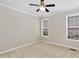 Neutral bedroom featuring carpeted floors, ceiling fan, and double windows for natural light at 1304 Trailing Rose Ct, Wake Forest, NC 27587
