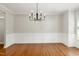 Bright dining room with hardwood floors, modern lighting, and classic wainscoting at 1304 Trailing Rose Ct, Wake Forest, NC 27587