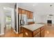 Bright kitchen with stainless appliances, hardwood floors, and an island next to the living room at 1304 Trailing Rose Ct, Wake Forest, NC 27587