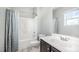 Bathroom featuring a shower-tub combo, a vanity with storage, and a window for natural light at 1305 Ivey Grove Ct, Fuquay Varina, NC 27526