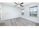 A bedroom with gray carpeting, a ceiling fan, and two windows with natural light at 1305 Ivey Grove Ct, Fuquay Varina, NC 27526