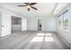 Spacious bedroom with gray carpet, tray ceiling, a ceiling fan, and an ensuite bathroom at 1305 Ivey Grove Ct, Fuquay Varina, NC 27526