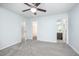 A bedroom with gray carpeting, a ceiling fan, and ensuite bathroom and walk-in closet at 1305 Ivey Grove Ct, Fuquay Varina, NC 27526