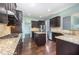 Modern kitchen with dark wood cabinets, granite countertops, stainless steel appliances, and a hardwood floor at 1305 Ivey Grove Ct, Fuquay Varina, NC 27526