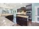 Spacious kitchen featuring dark wood cabinets, granite countertops, stainless steel appliances, and a central island at 1305 Ivey Grove Ct, Fuquay Varina, NC 27526
