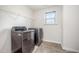 Modern laundry room with full-size washer and dryer and wire shelving at 1305 Ivey Grove Ct, Fuquay Varina, NC 27526