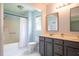 A bathroom featuring a double sink vanity and a shower/bathtub combination with a white shower curtain and light blue walls at 1309 Sweet Charm Ln, Knightdale, NC 27545