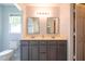 A full bathroom shows a double sink vanity with dark cabinets and black framed mirrors with plenty of natural light at 1309 Sweet Charm Ln, Knightdale, NC 27545