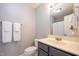 A partial view of a bathroom featuring a single sink vanity with gray cabinets and marble countertops at 1309 Sweet Charm Ln, Knightdale, NC 27545