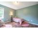 A cute bedroom features a large window, wood-look floors and pink accents at 1309 Sweet Charm Ln, Knightdale, NC 27545