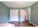 A bedroom features an open door to an en suite bathroom and a large closet with sliding doors and wood-look floors at 1309 Sweet Charm Ln, Knightdale, NC 27545